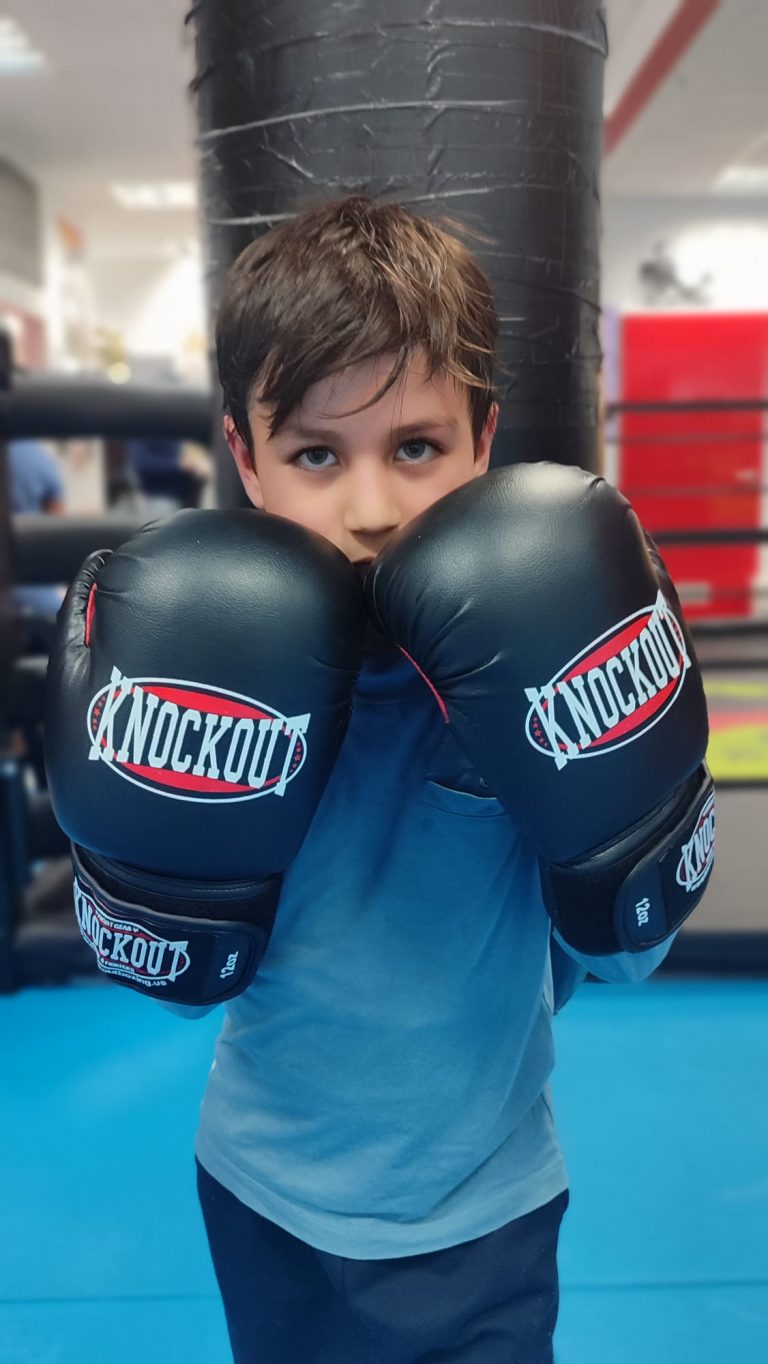 Junge mit Boxhandschuhen in Deckung